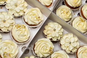 Cupcakes till ett bröllop, dekorerade i enkel men vacker stil. Här i vanilj.