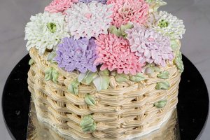 Tårta i form av en korg fylld med spritsade blommor.