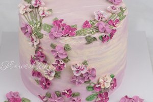 Blåbär/Citrontårta dekorerad med blommor i lila &amp;amp; rosa färger.