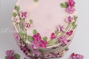 Blåbär/Citrontårta dekorerad med blommor i lila &amp;amp; rosa färger.