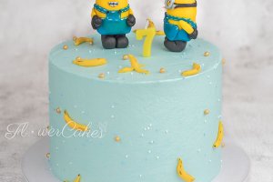 Tårta med karamelliserade bananer och kräm av chokladganache. Minions är gjorda för hand av sockerpasta & marsipan och bananerna av sockerpasta.