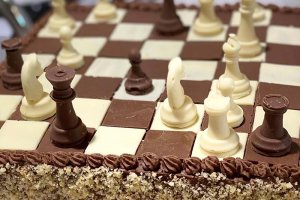 Tårta i form av ett schackbräde med rutor &amp;amp; figurer av tempererad choklad. 