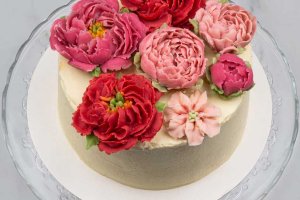 Enkel vit tårta med fullt fokus på blommor i dekoren.
Prisgrupp: Blomdekor